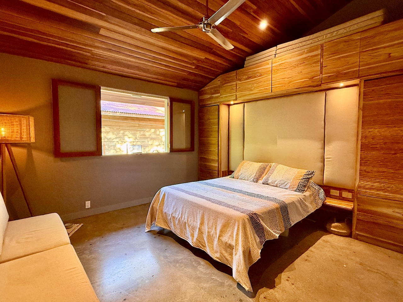 Bedroom with wood-paneled walls and ceiling fan