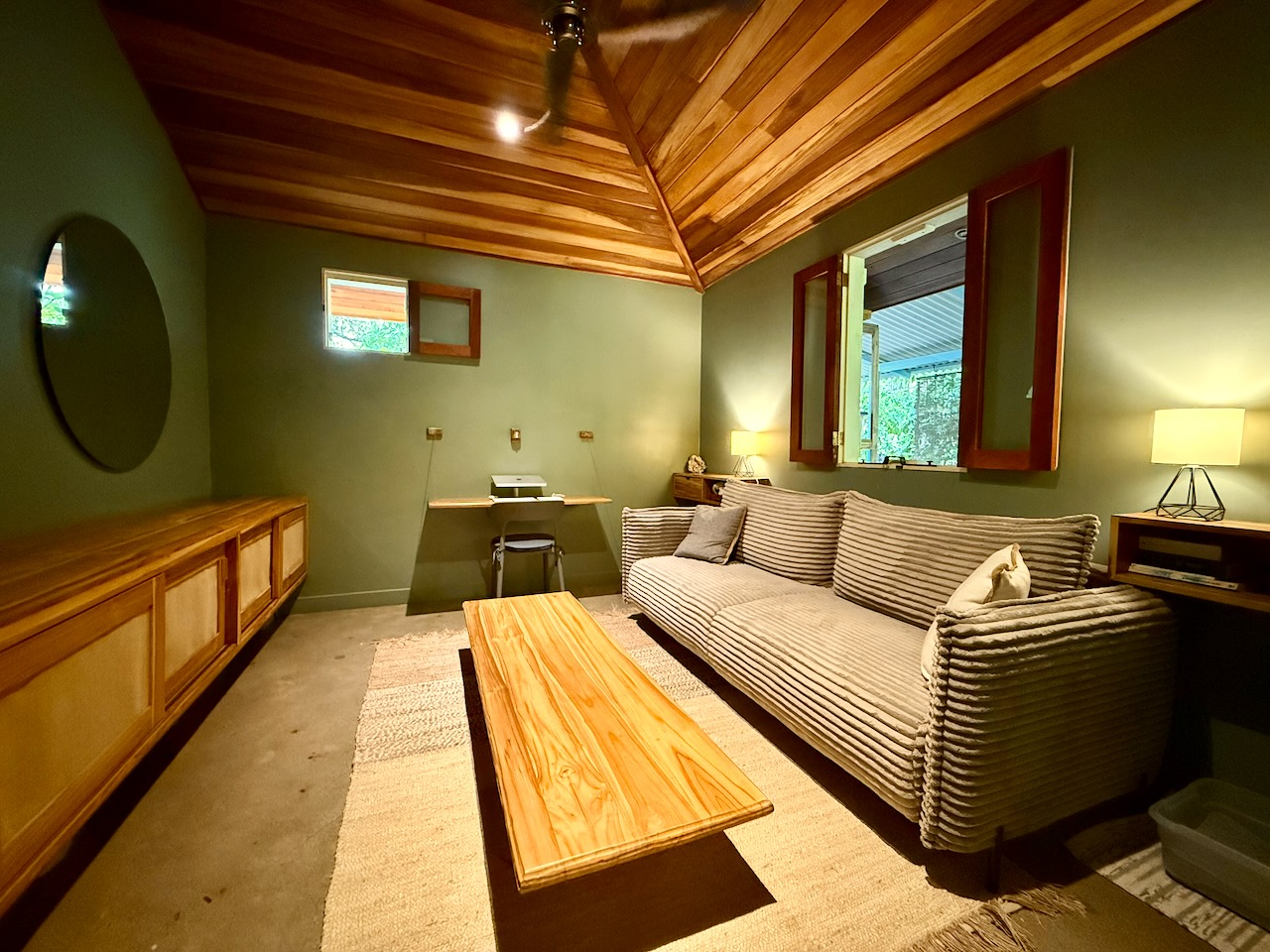 Sage green living room with corduroy sofa and wood ceiling