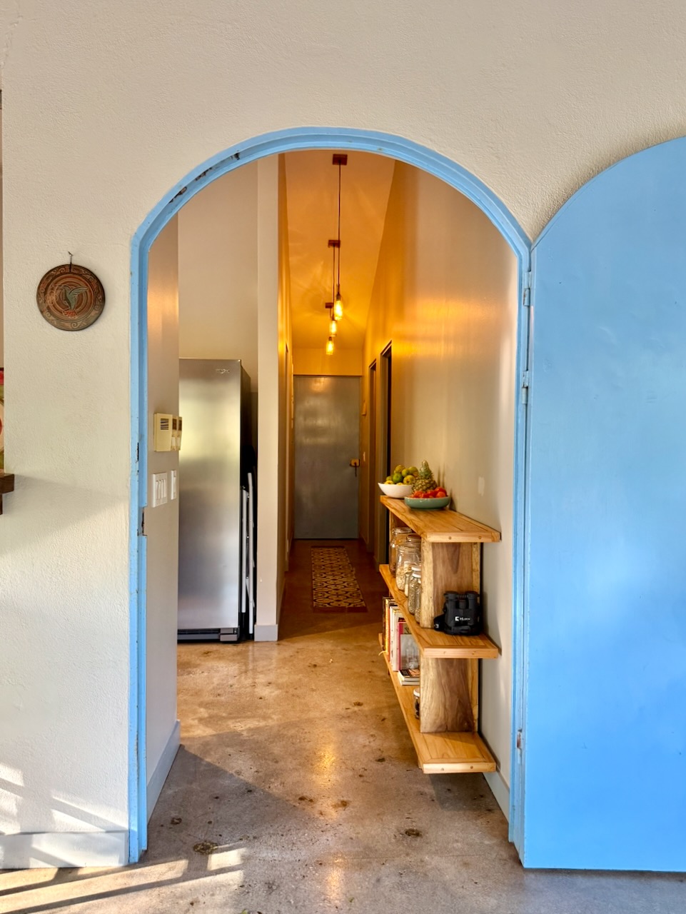 Blue arched doorway leading to kitchen hallway