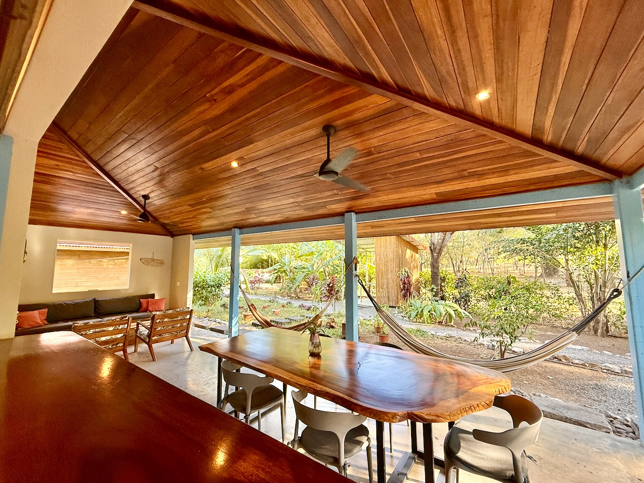 Open-air dining room with hammock and tropical view