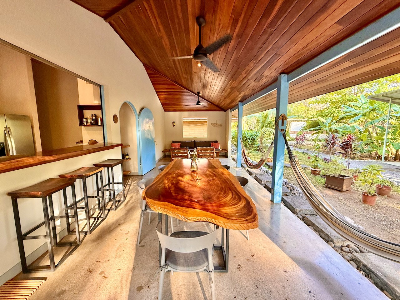 Live-edge wood dining table with bar seating and arched blue doors